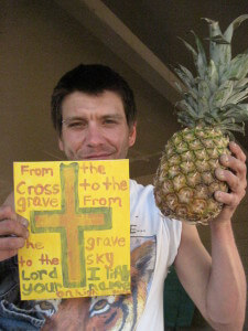 Chris holding his painting and ripe pineapple