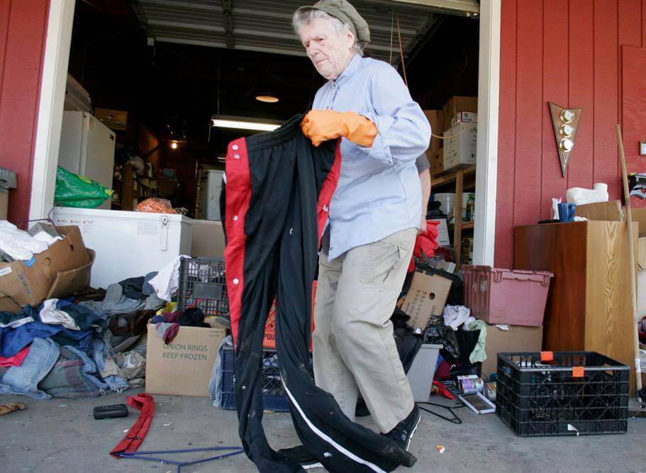 Genevieve Cochran sorts clothes that were left in front of the red barn at the Anawim Sanctuary in Gresham, Oregon
